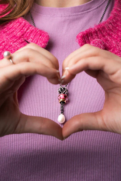 Trollbeads armbånd med jordbærkvarts og en Kærlighedens kerub kugle samt en lille rund månesten.