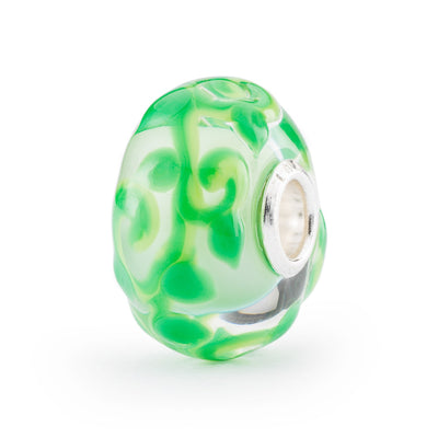 En smuk glaskugle med en fortryllende design, der minder om en magisk bønne, med et swirl-design i grøn.
